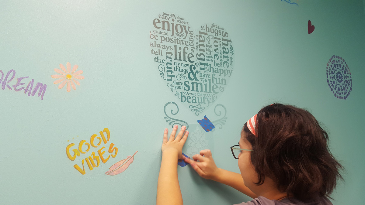 El personal de Suncoast Credit Union pinta a mano decoraciones en el baño de niñas del Centre for Girls