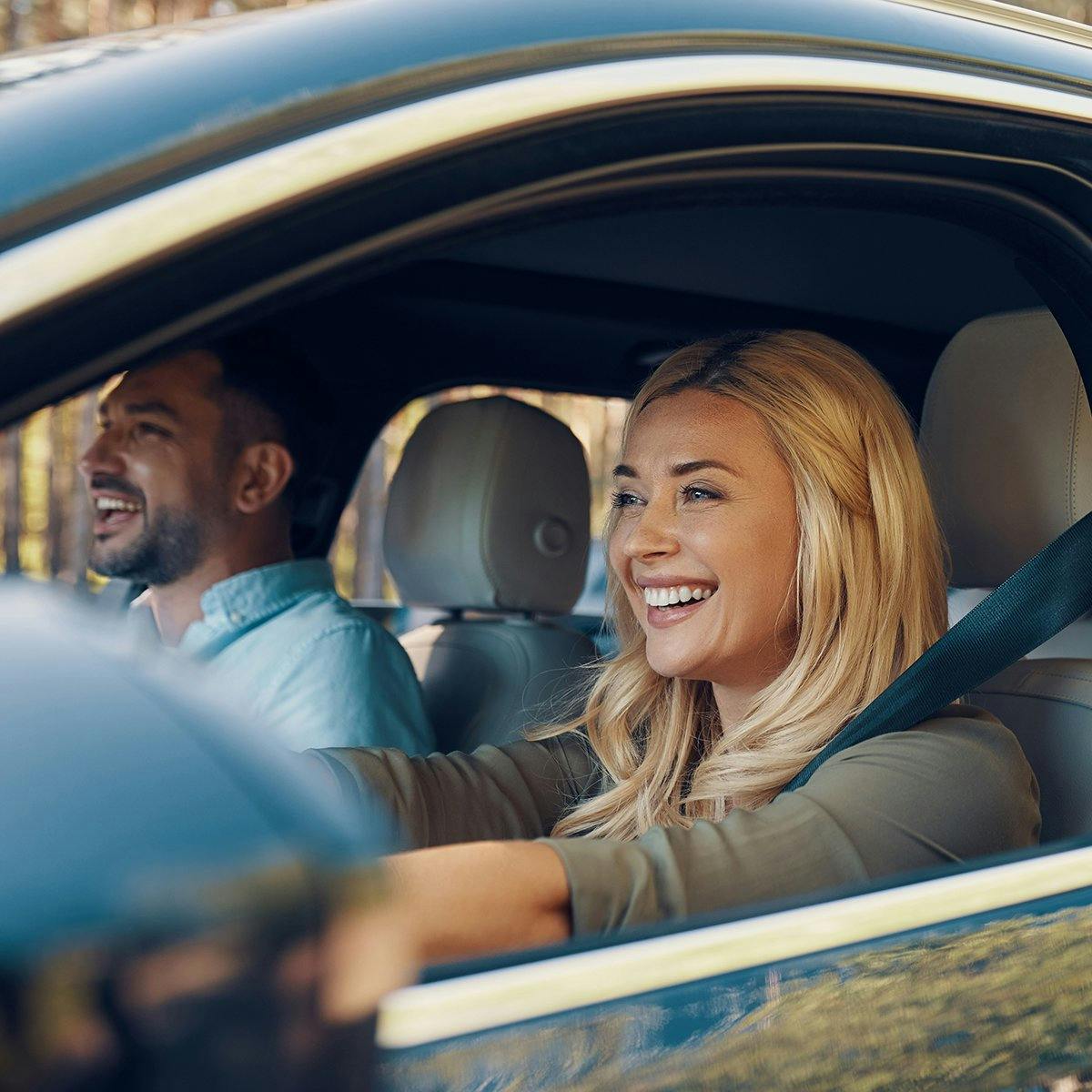 Una pareja sonríe en un auto